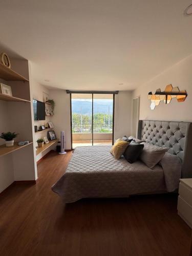 a bedroom with a large bed with a large window at Aparta estudio muy bien ubicado in Medellín