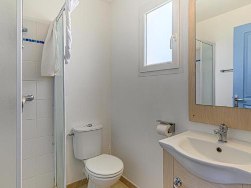 a bathroom with a toilet and a sink and a mirror at Apartment in Brittany near Pentrez Beach in Saint-Nic