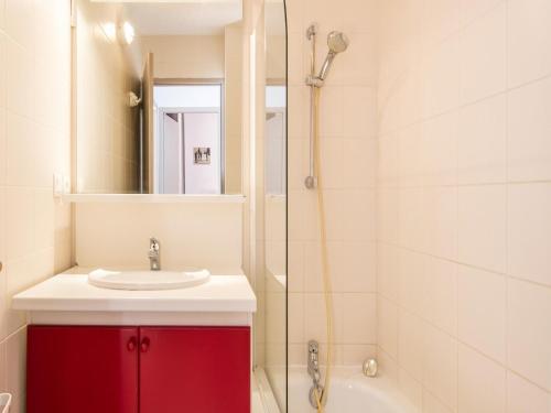 La salle de bains est pourvue d'un lavabo rouge et d'une douche. dans l'établissement Apartment in France with Stunning Ski Views, à Valloire