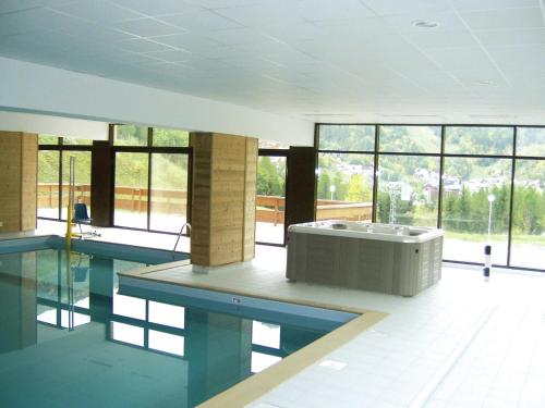 - une piscine avec baignoire dans une chambre dotée de fenêtres dans l'établissement Apartment in France with Stunning Ski Views, à Valloire