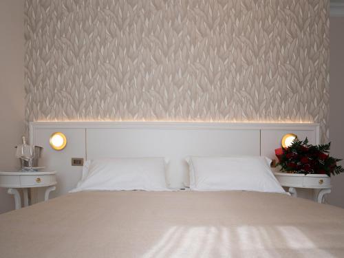 a bedroom with a white bed with two night stands at Hotel Sicilia in Enna