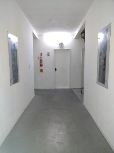 a hallway with white walls and a white door at Pousada Flay 7 minutos Próximo do Aeroporto de Florianópolis in Florianópolis