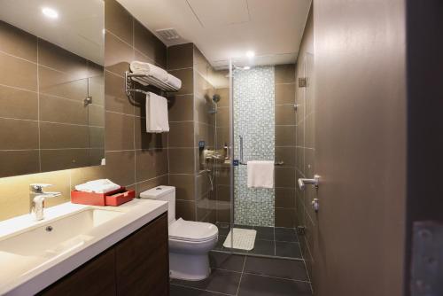 a bathroom with a toilet and a sink and a shower at Signata Genting Highlands in Genting Highlands