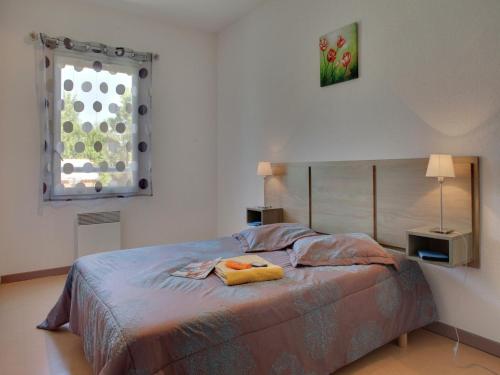 une chambre avec un lit avec deux lampes et une fenêtre dans l'établissement Holiday Home w Pool near Béziers, à Colombiers