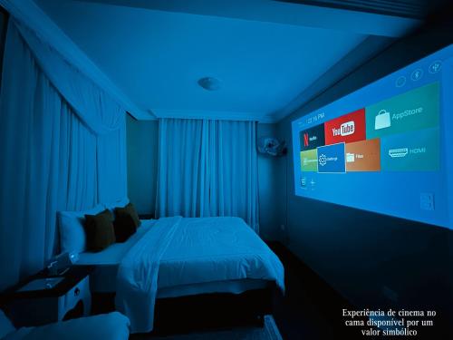 - une chambre avec un lit à éclairage bleu dans l'établissement Pavilhão Egípcio, à Curitiba