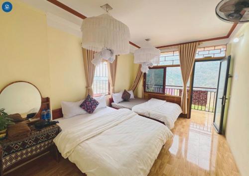 two beds in a room with a mirror and windows at Ba Be Lake View Homestay in An Ma