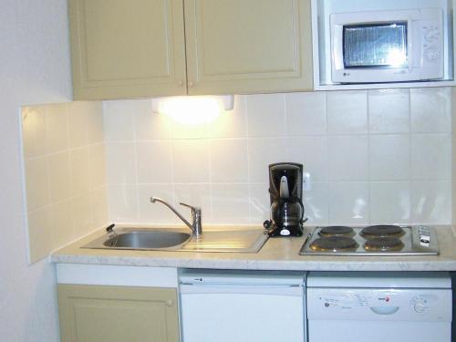 une cuisine avec un évier et un micro-ondes dans l'établissement Apartment in France with Stunning Ski Views, à Valloire