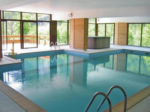 - une piscine d'eau bleue dans un bâtiment avec fenêtres dans l'établissement Apartment in France with Stunning Ski Views, à Valloire