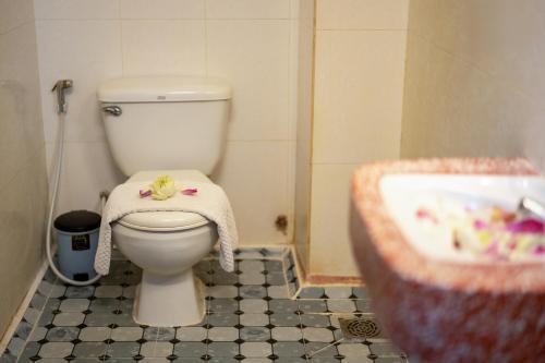 a bathroom with a toilet and a sink at Okay One Hotel in Phumi Ta Phul