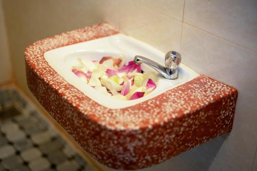a red and white counter with a sink at Okay One Hotel in Phumi Ta Phul