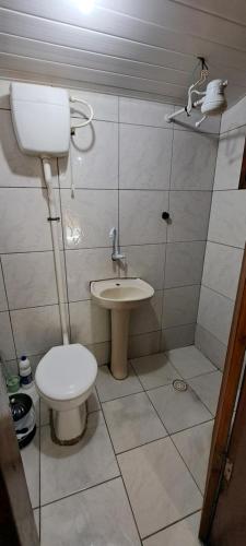 a bathroom with a toilet and a sink at Chácara gratidão a Deus in Morretes