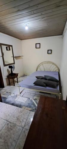 a bedroom with a bed and a table in it at Chácara gratidão a Deus in Morretes