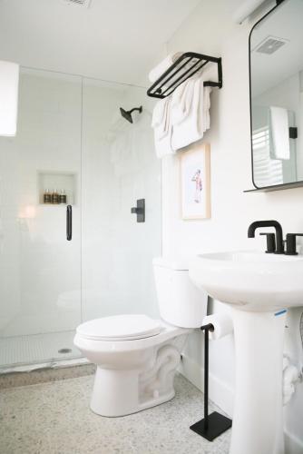 a white bathroom with a toilet and a sink at Waterford Inn Provincetown in Provincetown