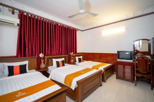 a hotel room with two beds and a television at Okay One Hotel in Phumi Ta Phul