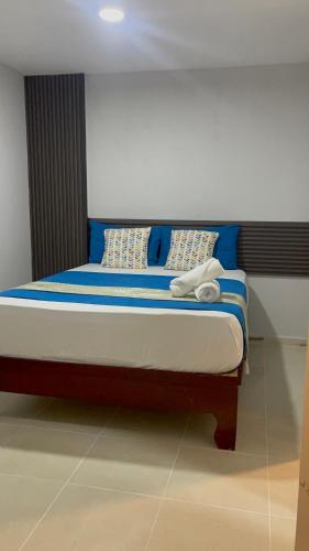 a bed with blue and white pillows on it at JM 257 Gh in Santo Domingo