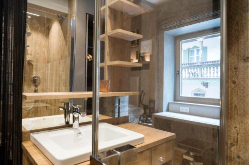a bathroom with a sink and a window at Boutique Hotel im Auracher Löchl in Kufstein