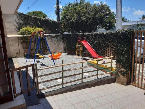 a playground with two swings and a slide at Casa inteira no Centro de Jacareí próximo à São José dos Campos in Jacareí