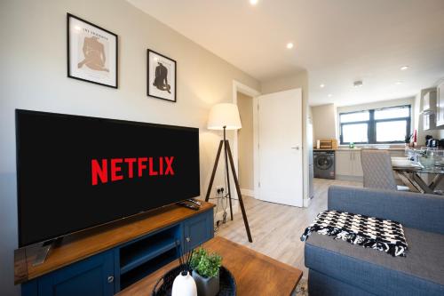a living room with a television on a wall at Modern 2 Bedroom Flat, Central Chatham, Self Check-in in Chatham