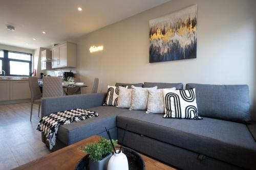 a living room with a blue couch with pillows at Modern 2 Bedroom Flat, Central Chatham, Self Check-in in Chatham