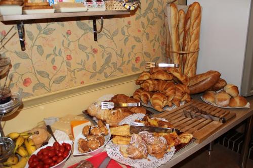 a table with many different types of bread and pastries at Hotel Bristol in Châlons-en-Champagne