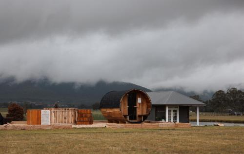 a small house with a barrel and a shed at The Wellness Farm Broke in Broke