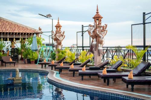 a pool at a resort with chaise lounges at Okay One Hotel in Phumi Ta Phul