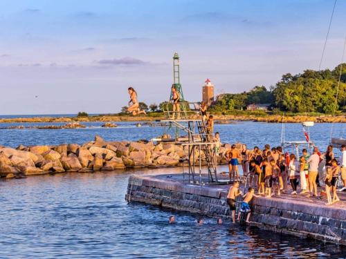 a group of people standing on a dock in the water at Svaneke - The Munker in Svaneke