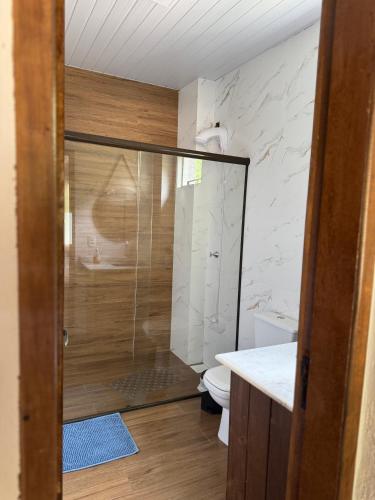a bathroom with a glass shower with a toilet at Chácara do Paulo in Santo Amaro da Imperatriz