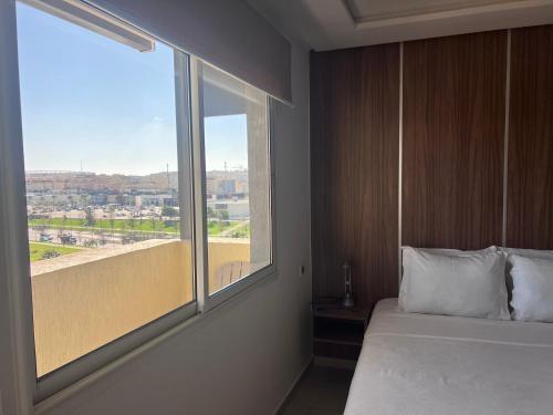 a bedroom with a bed and a large window at Appart Hotel Monaco in Tangier