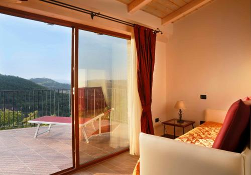 a room with a view of a balcony with a couch at Colleverde Country House & SPA Urbino in Urbino