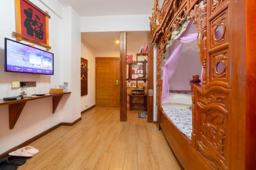 a room with a bed with a tub and a television at 张家界星河清梦民俗客栈 in Zhangjiajie