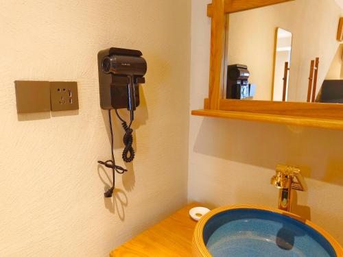a bathroom with a sink with a camera on the wall at Phoenix Dragon M.I.C.E Hotel in Kunming