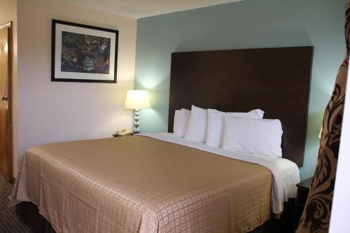 a hotel room with a large bed with white pillows at Sterling Inn near IAG Airport in Niagara Falls
