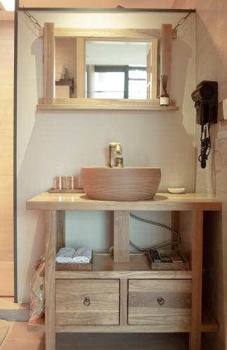 a bathroom with a wooden sink and a mirror at Phoenix Dragon M.I.C.E Hotel in Kunming