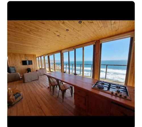 a large room with a table with a view of the ocean at Aroma a mar in Navidad