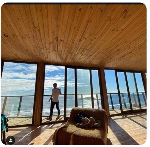 a man walking in a room with windows at Aroma a mar in Navidad