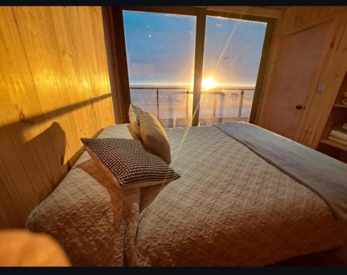 a bedroom with a bed with a view of the ocean at Aroma a mar in Navidad