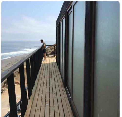 a man standing on a balcony looking at the ocean at Aroma a mar in Navidad