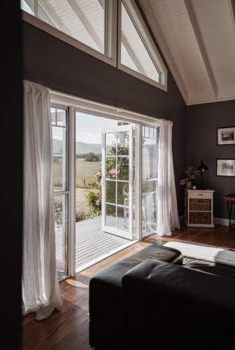 a living room with a large window and a couch at The Wellness Farm Broke in Broke