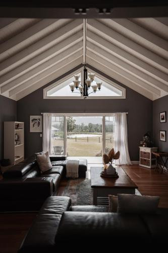 a living room with a couch and a large window at The Wellness Farm Broke in Broke