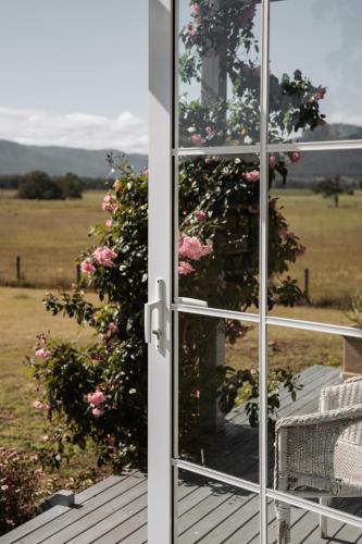 an open door with a view of a field of flowers at The Wellness Farm Broke in Broke