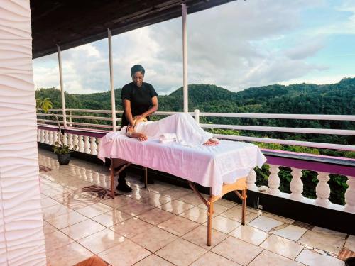 un uomo seduto su un tavolo sul balcone di Nine Mile Resort Village and Travel a Stepney