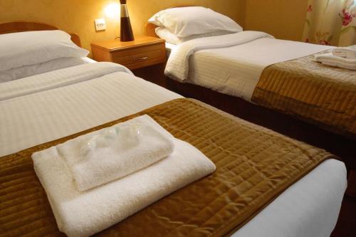 a hotel room with two beds with towels on them at Royal Mackintosh Hotel in Dunbar