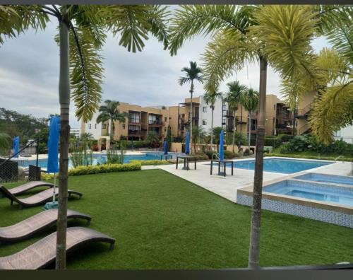 un parc avec des palmiers et une piscine dans l'établissement Apartamento vacacional en el corazón del Eje Cafetero La Tebaida, Quindío, à La Tebaida