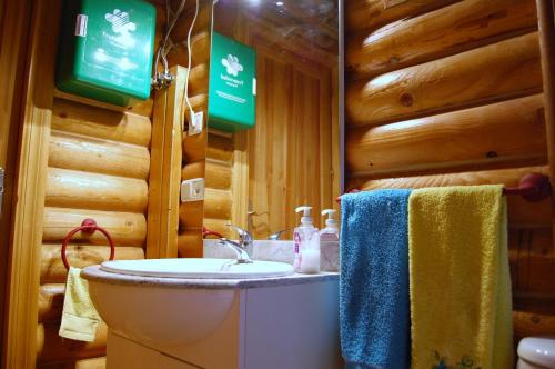 un bagno con lavandino e servizi igienici in una baita di tronchi di villa pereza 2 a Casas de Roldán