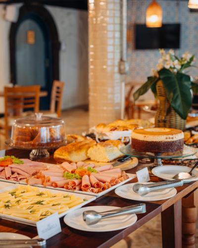 a table with many different types of food on it at Own Búzios Beach Hotel in Búzios
