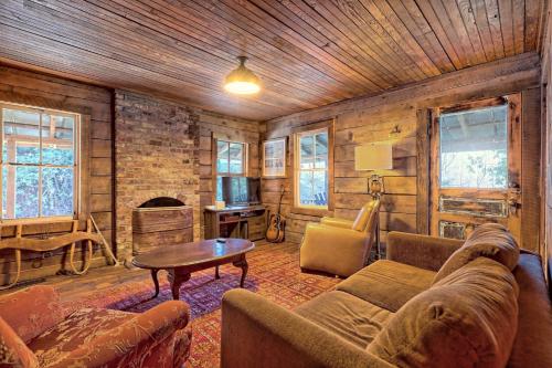 a living room with a couch and a table at Historic Cabin with Porch and Firepit 5 Minutes from Bryson City in Bryson City