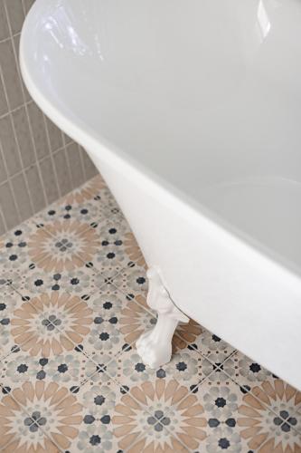 a white toilet sitting on a tile floor in a bathroom at The Wellness Farm Broke in Broke