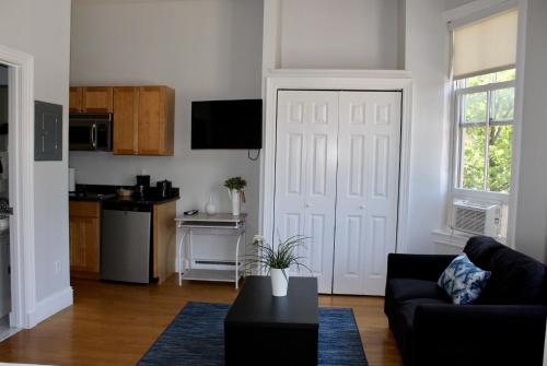 a living room with a black couch and a white door at Stylish Downtown Studio in the SouthEnd, C.Ave# 3 in Boston