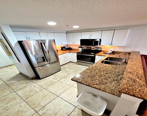una cucina con frigorifero ed elettrodomestici in acciaio inossidabile di Wyndham Ocean Walk 2 BR Resort Condo Direct Oceanfront - Daytona Funland 2226 a Daytona Beach